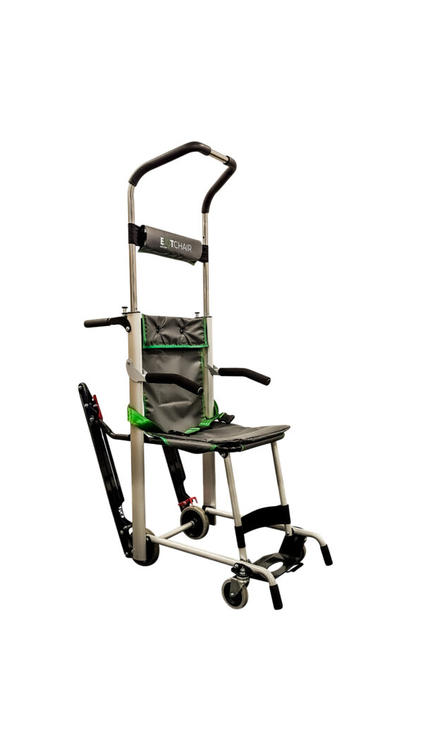 The Exitmaster Versa Elite Evacuation Chair, showcasing its premium green seat, black frame, four wheels, distinct top handle, and visible padded armrests and four-point safety harness.