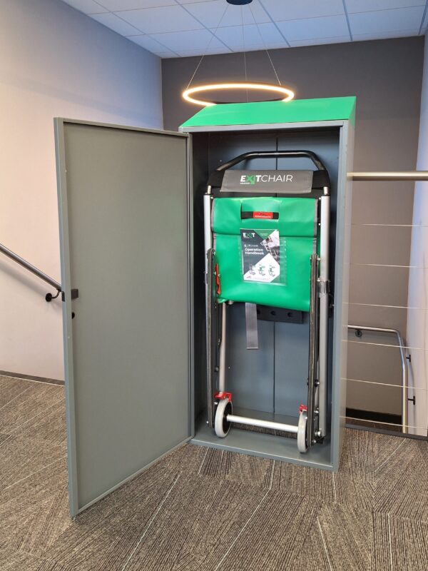 A grey Exitmaster Evacuation Chair Storage Cabinet with a transparent window or label area, designed to securely house an evacuation chair, against a white background.